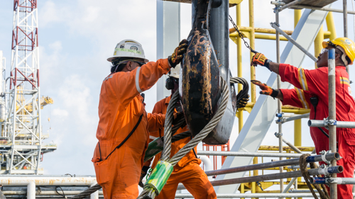 Offshore construction crews preparing the crane block for a heavy lifting